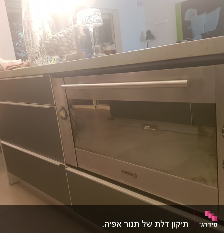 תנור אפור עם כפתורים עגולים במטבח מודרני